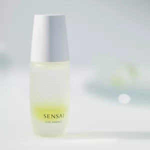 Dual Essence bottle on white surface with light blurred background